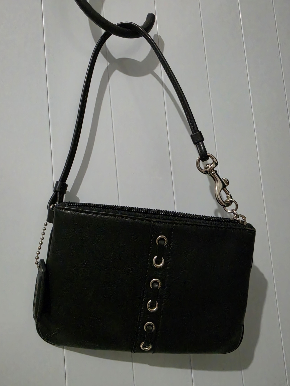 Authentic Coach black leather wristlet featuring a vertical eyelet/grommet corse